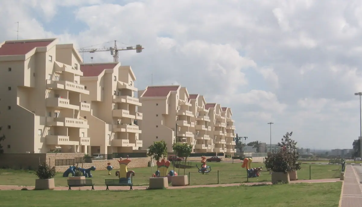 שכונת מגורים חדשה בכפר סבא: בנייני דירות עם מרפסות לצד גינה ומגרש משחקים.